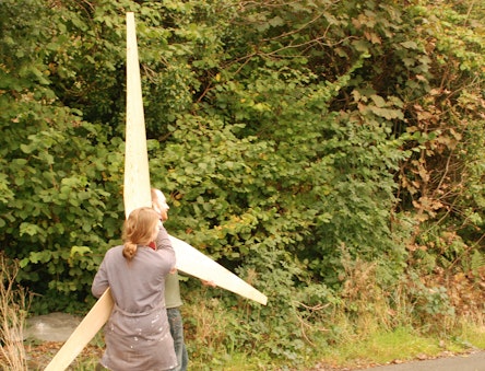 People carrying the blades of a handmade wind turbine