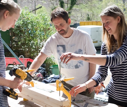 3 people working with wood on a building course