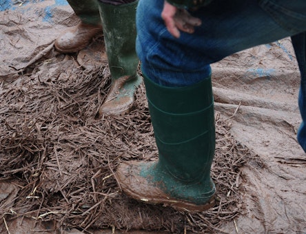 Mixing cob with feet on a tarp