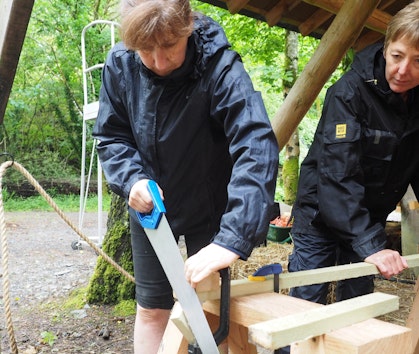 sawing wood on a tiny house course
