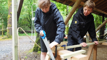 Sawing wood on a tiny house course