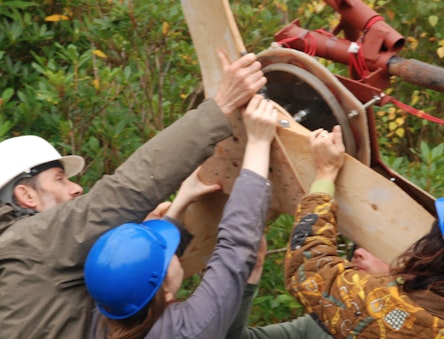 People adding the blades to a small wind turbine
