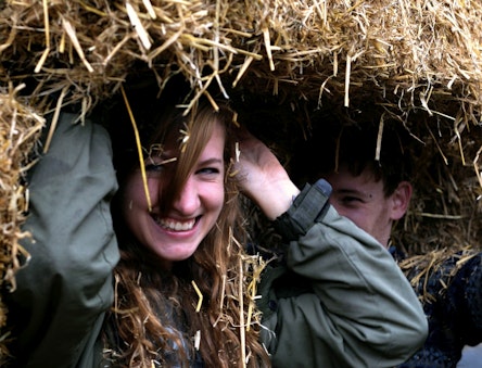Women holding up a straw bale