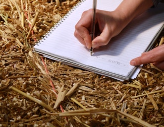 Writing on a book resting on a straw bale