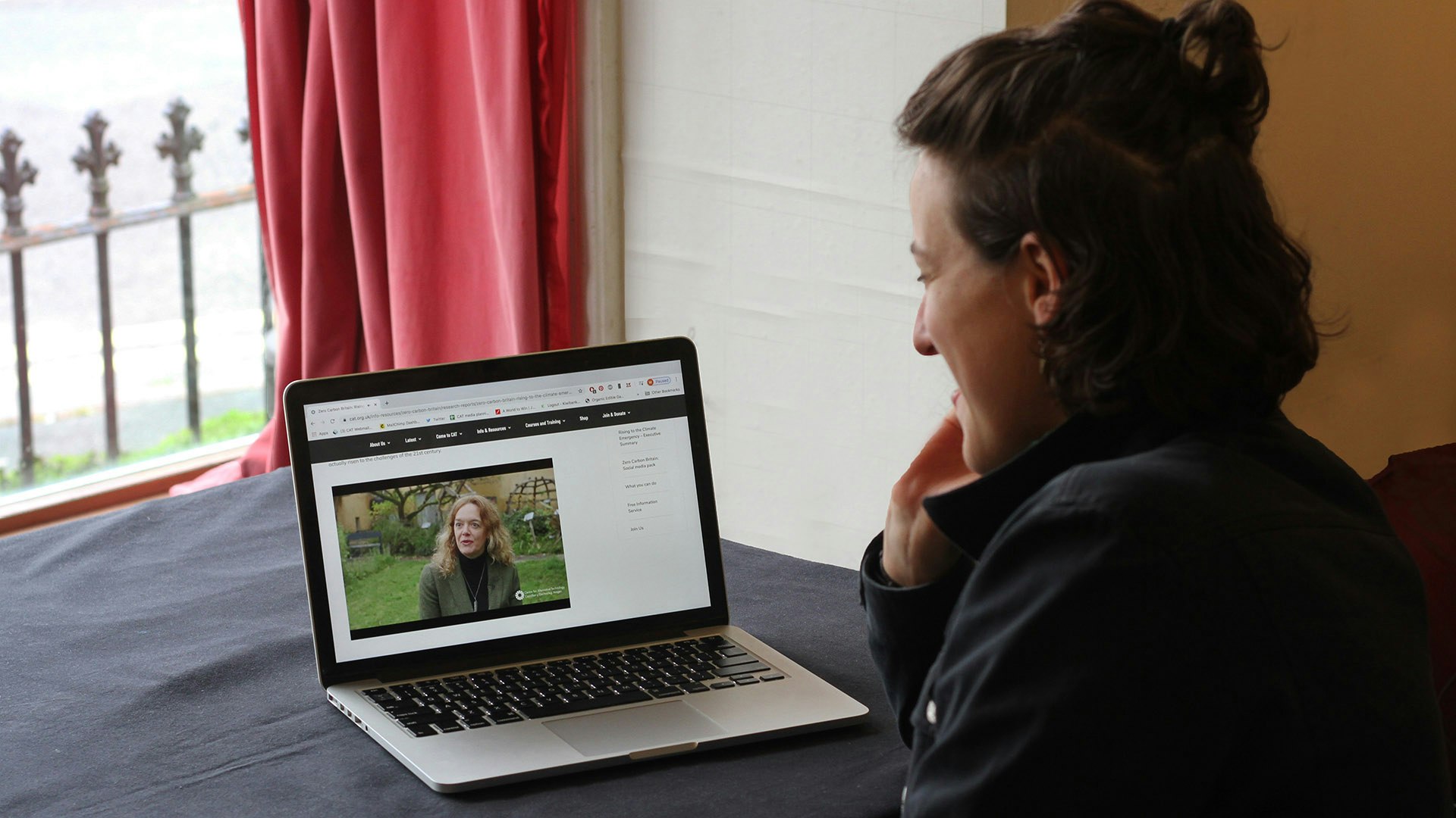 A Woman watches a video about CAT on a laptop