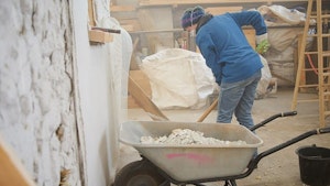 Removing lime plaster from strawbale walls.