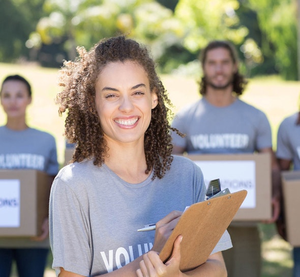 a person smiles holding a clipboard