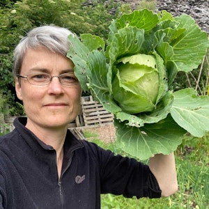 Ruth holding up a freshly harvested cabbage