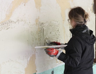 Women learning to plaster on a CAT Retrofit course